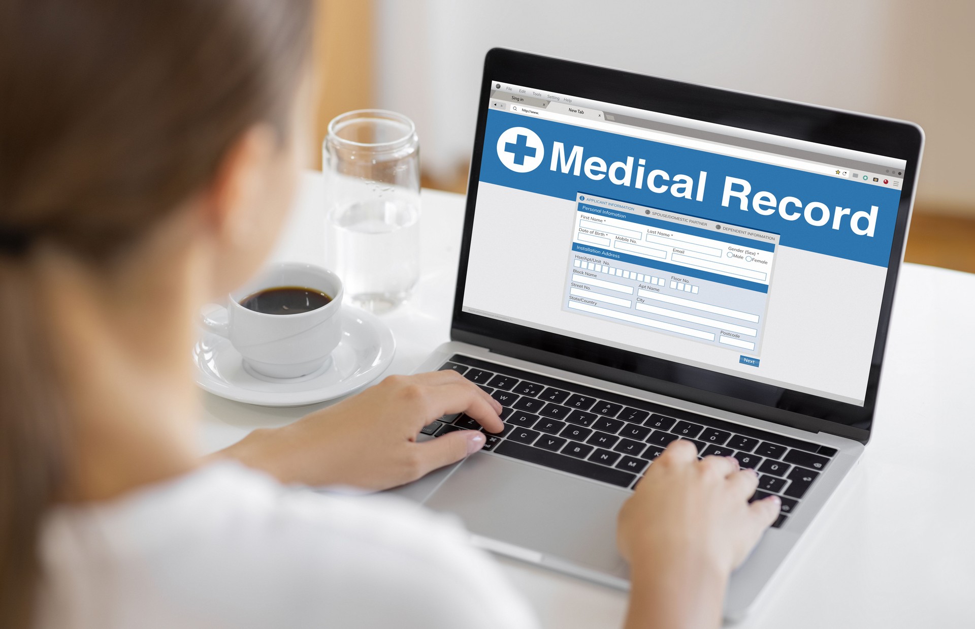 Person Accessing Online Medical Record on Laptop at Home
