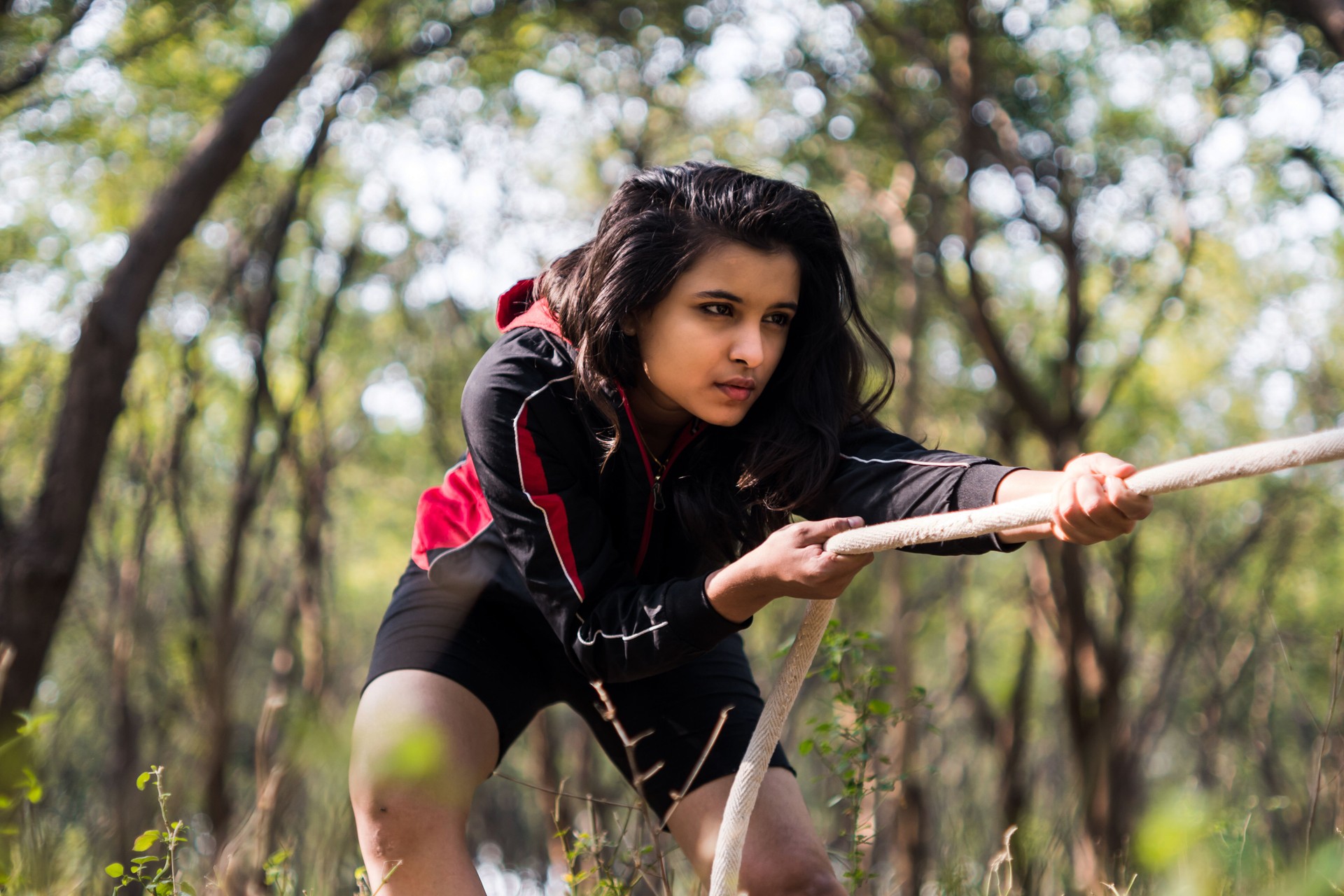 A sporty gymnast performs exercises with a rope in sportswear